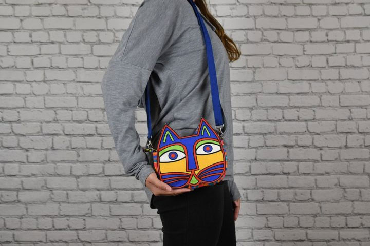 Woman holding a cat face-shaped crossbody bag